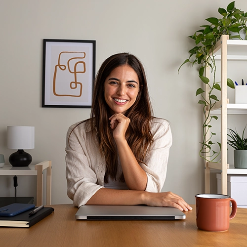smiling woman with her laptop on desk